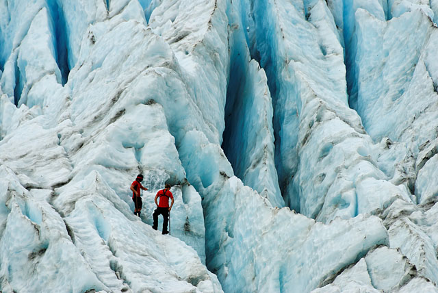 guides looking into glacier's crevasse